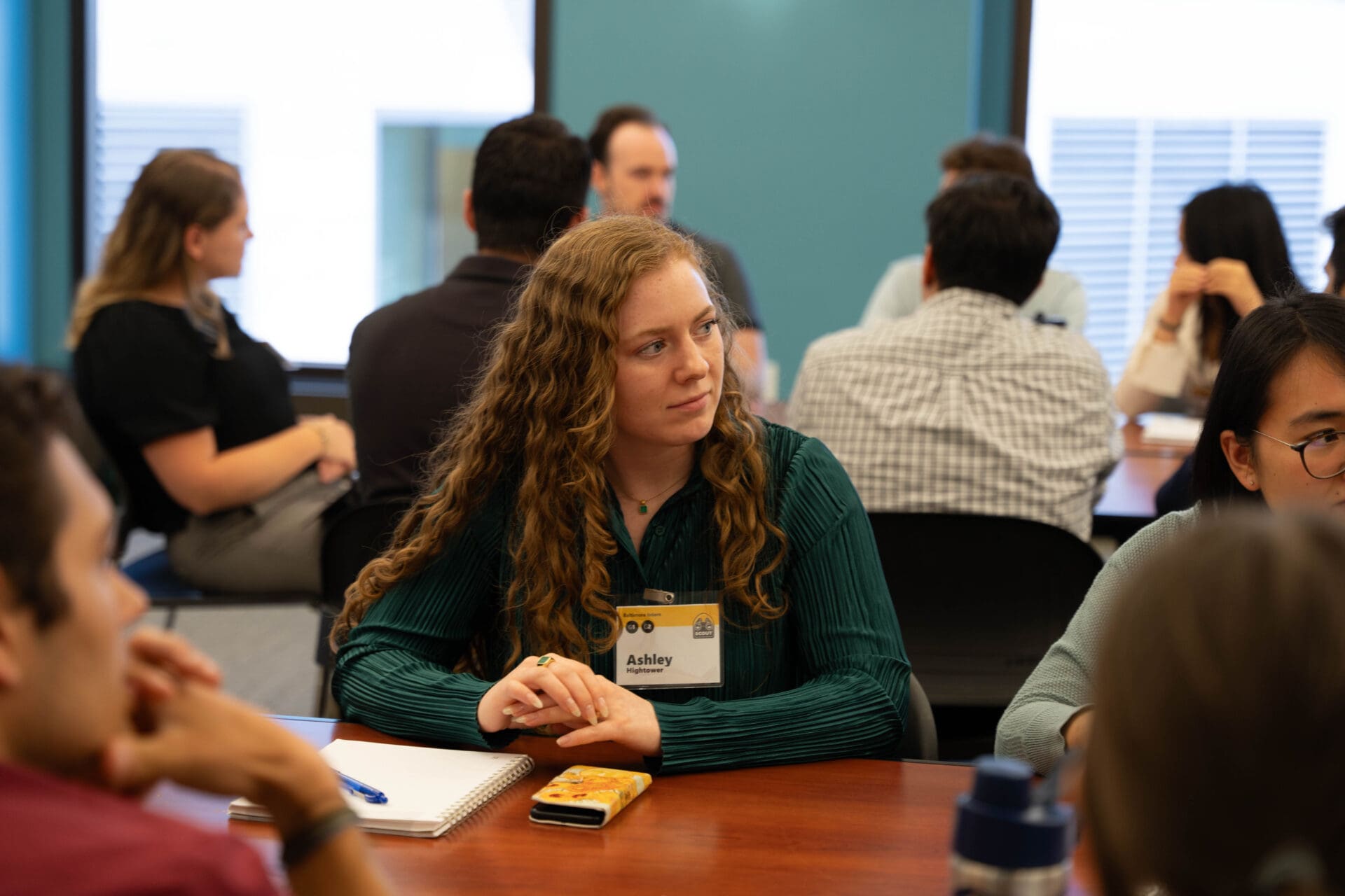 A person at a table listening to discussion.