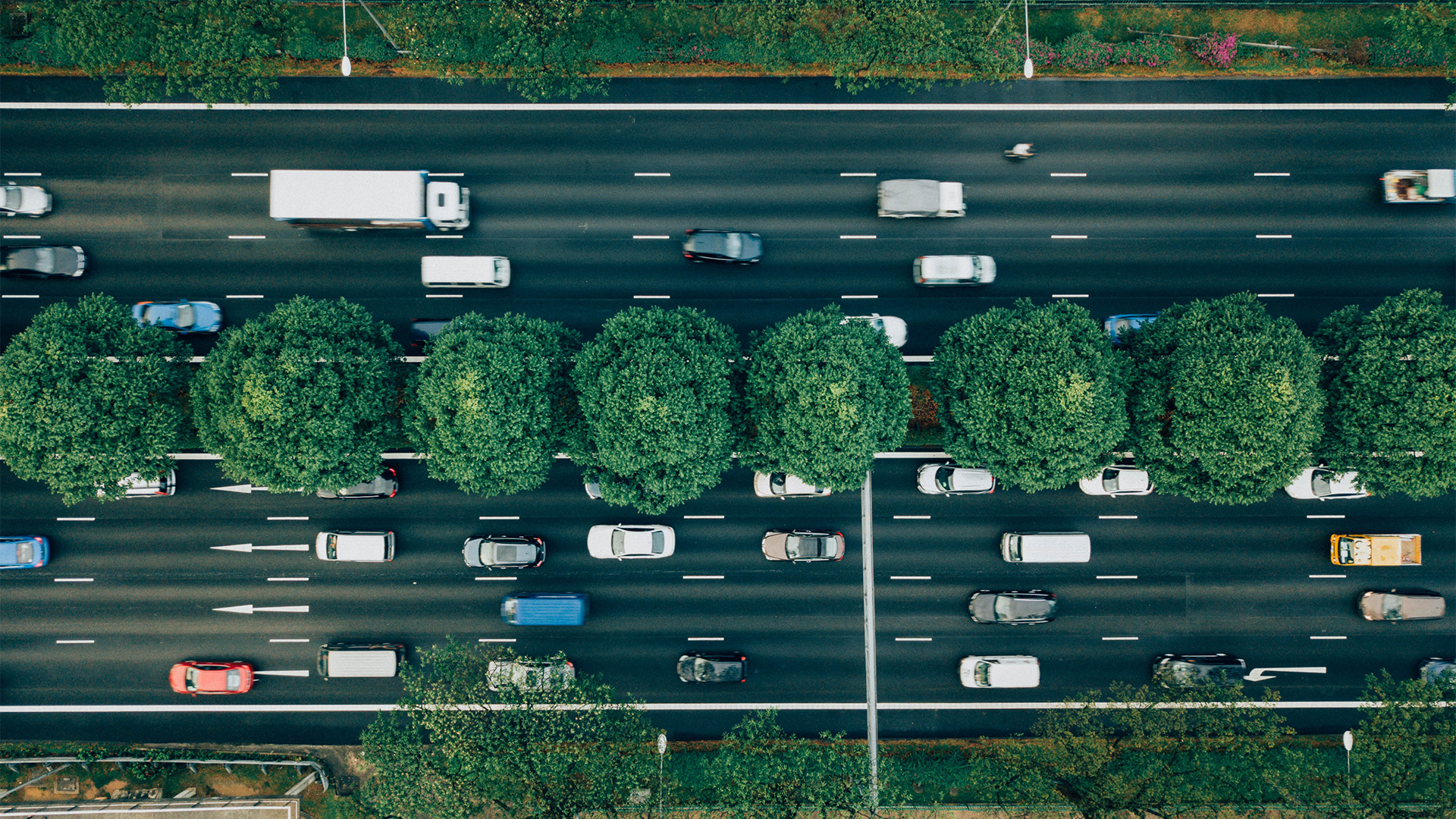 Aerial view of a highway with trees on either side.