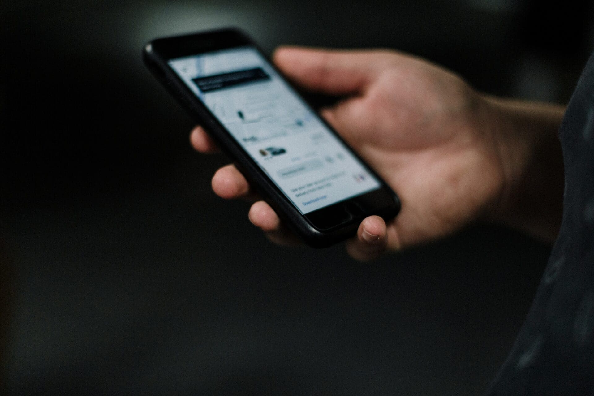 Hand holding a phone with a ridehail service app pulled up on the screen.