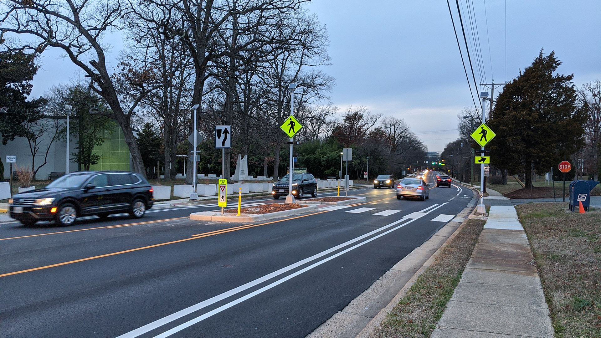 Roadway with one travel lane in each direction, bike lane on the sides, and pedestrian crossing