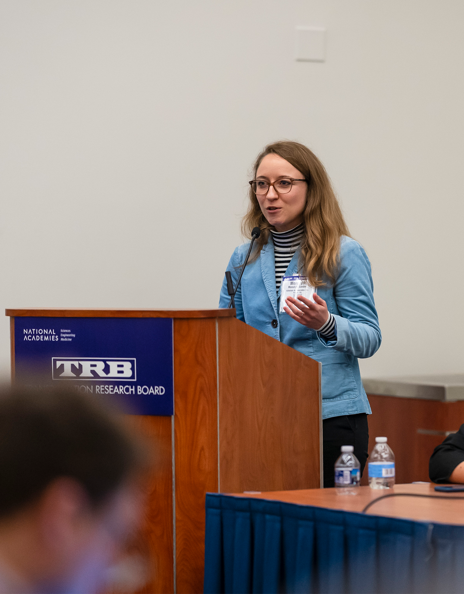 Meredyth Sanders speaking to an audience at a podium.