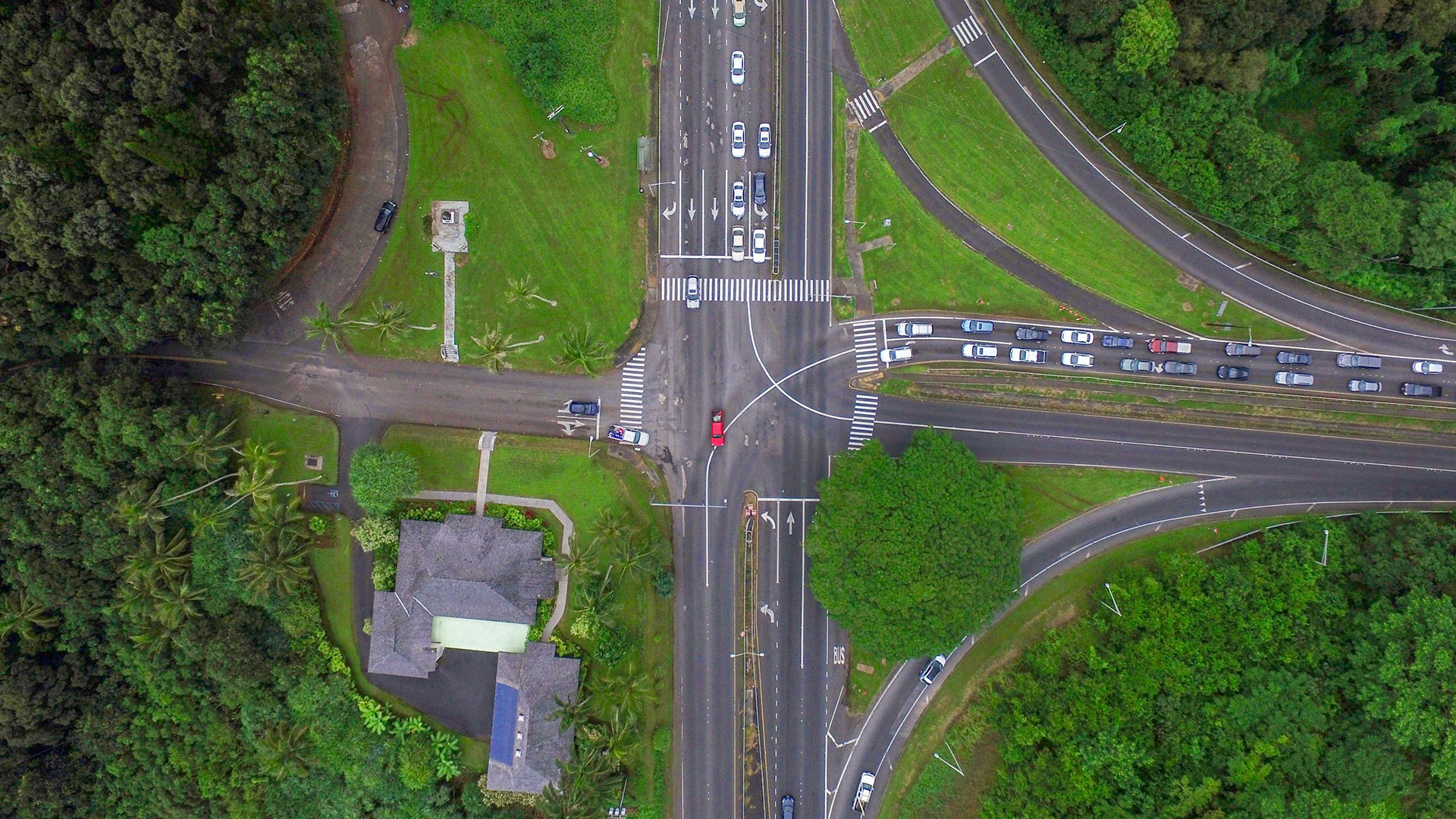 Aerial view of intersection in rural area with a car making a left turn