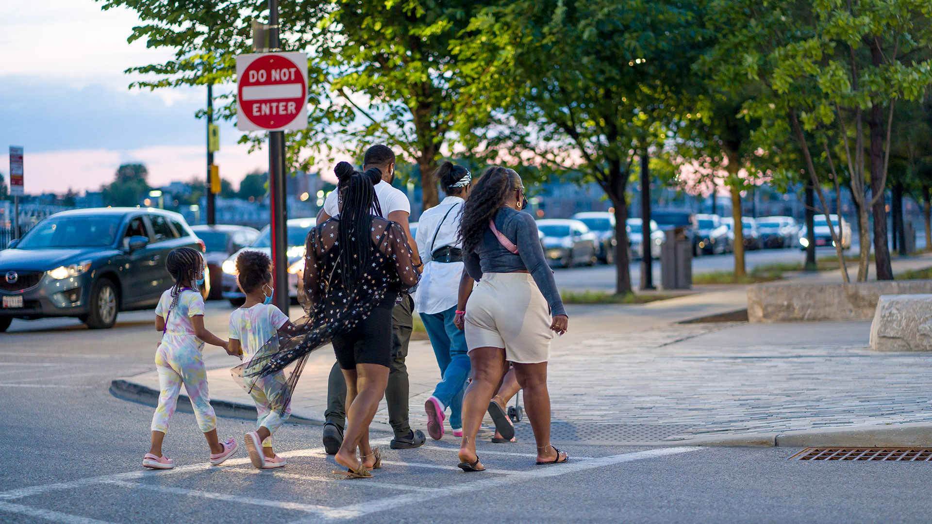 Family crossing a street on a crosswalk