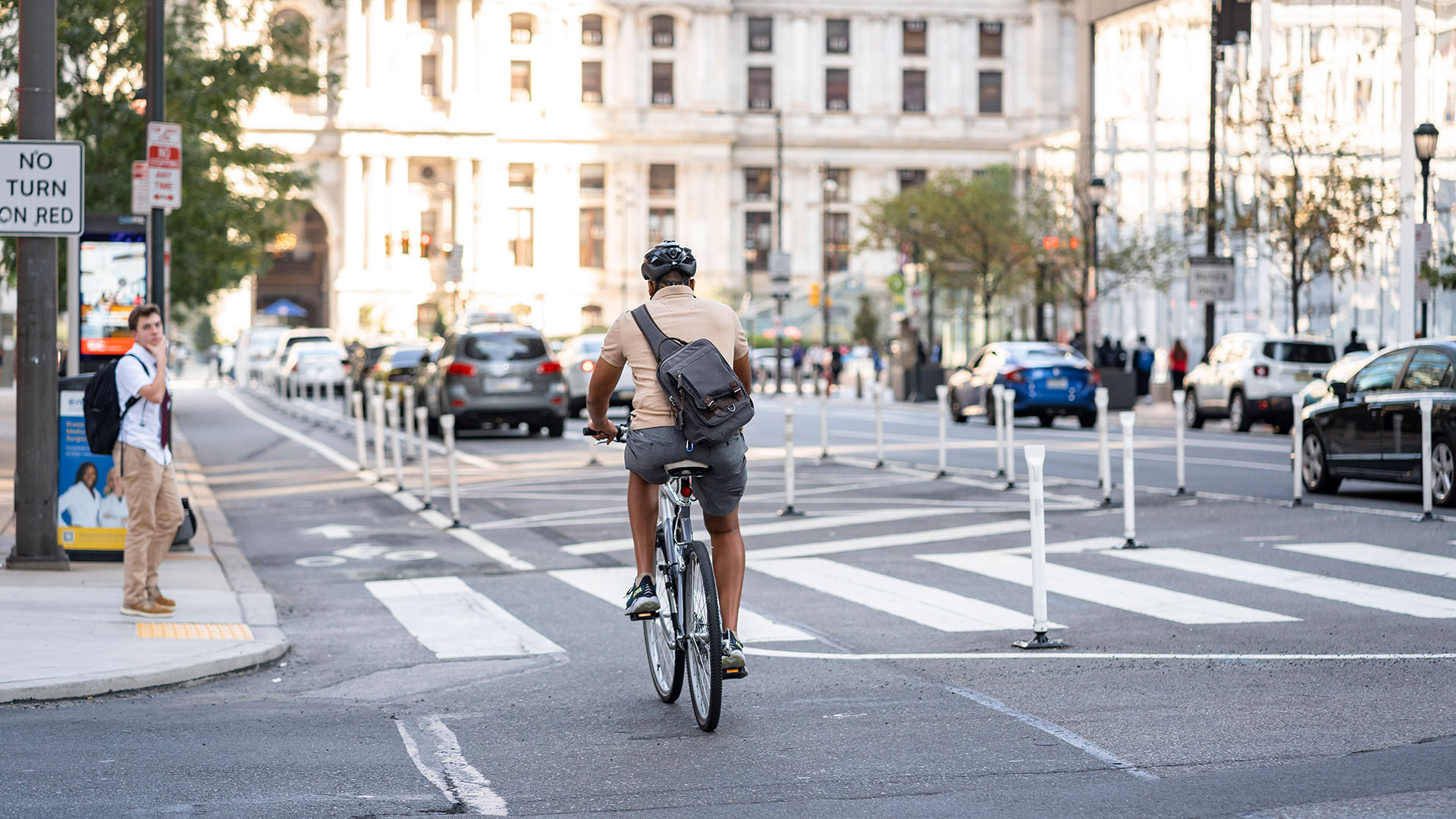 Person on bicycle rides through a protected bike lane on a city street