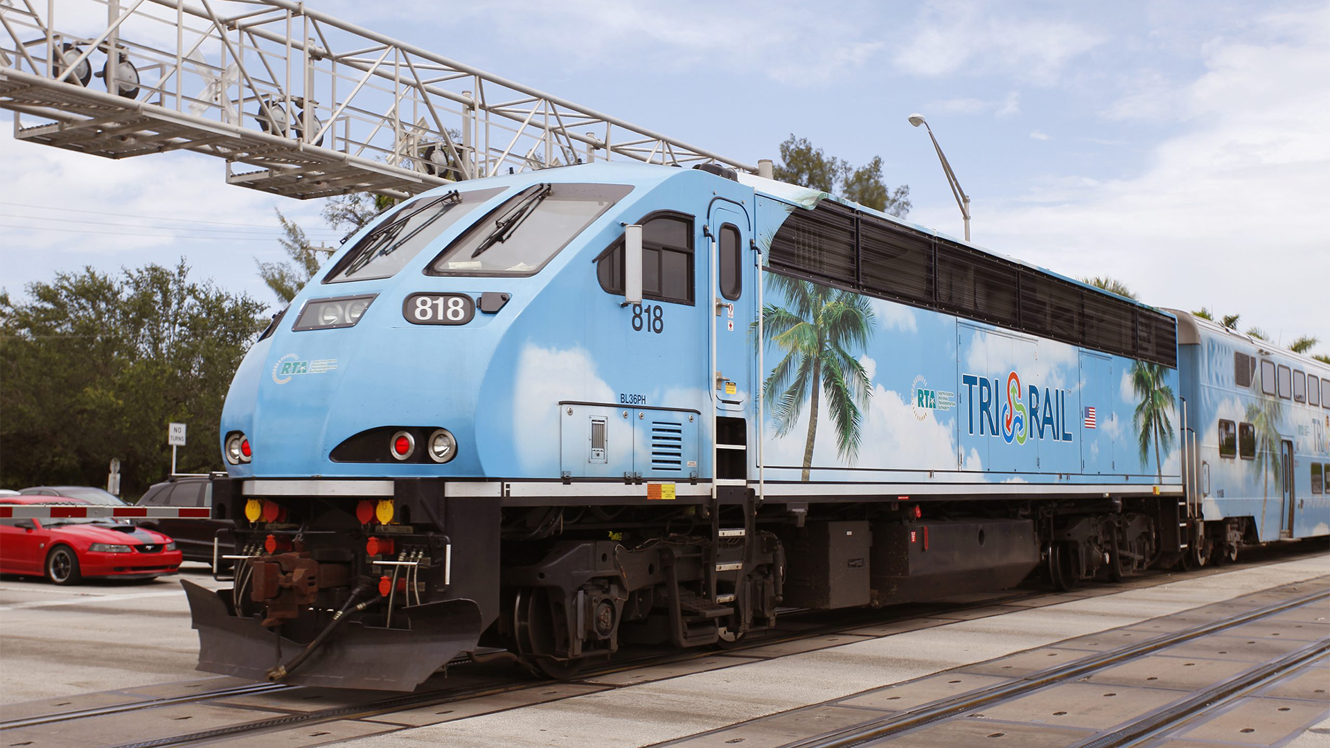 Front of a Miami's Tri-Rail Train with blue skies in the background.