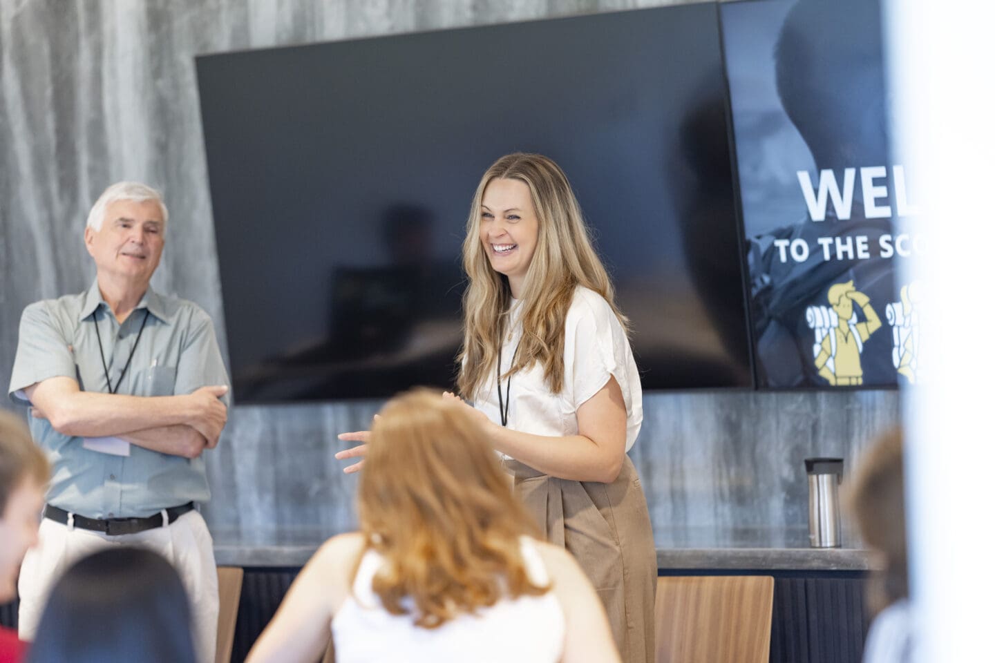 Woman smiling and speaking to audience.