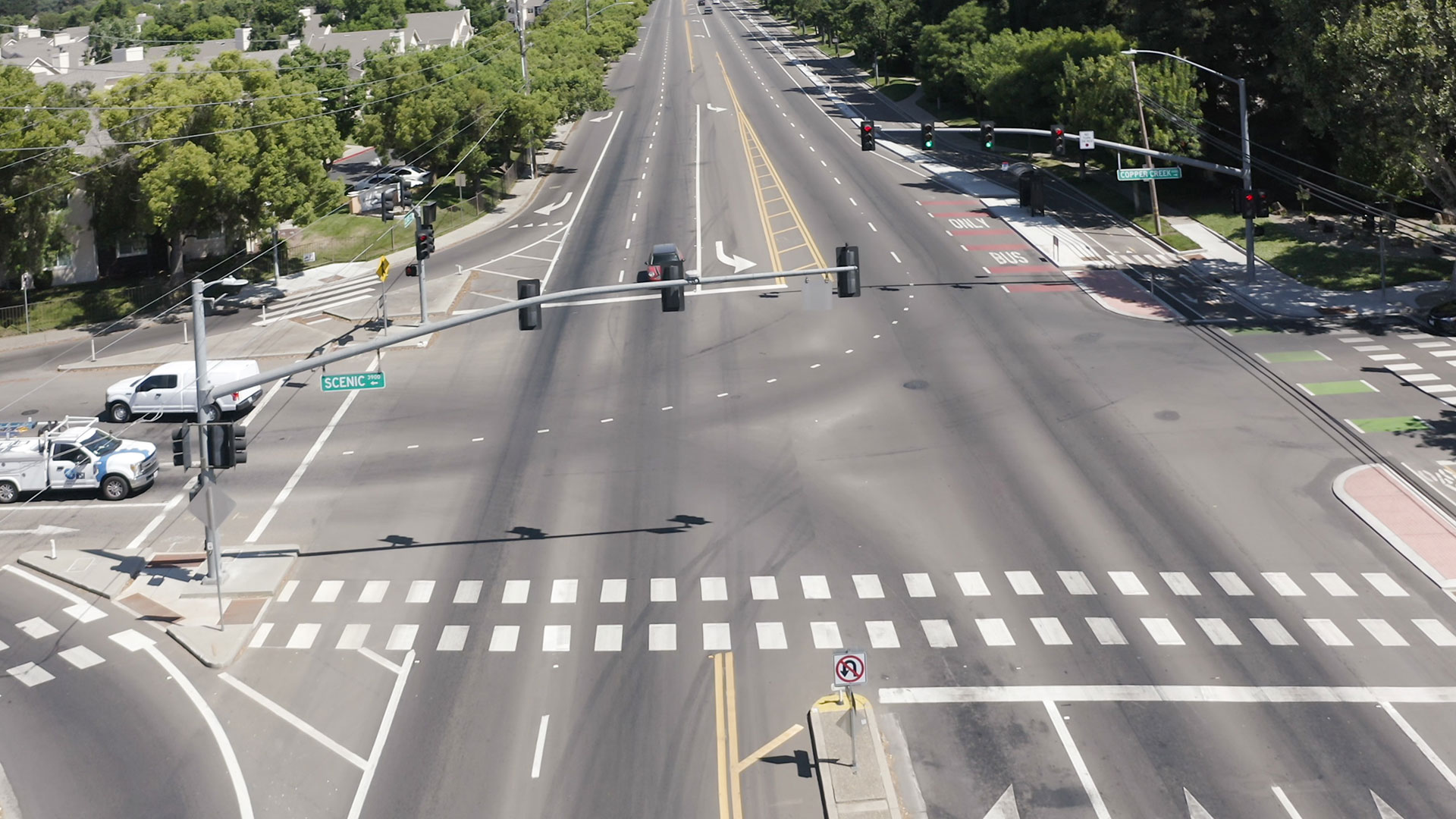 A drone shot of a higher-speed roadway with a bike lane on the right side.