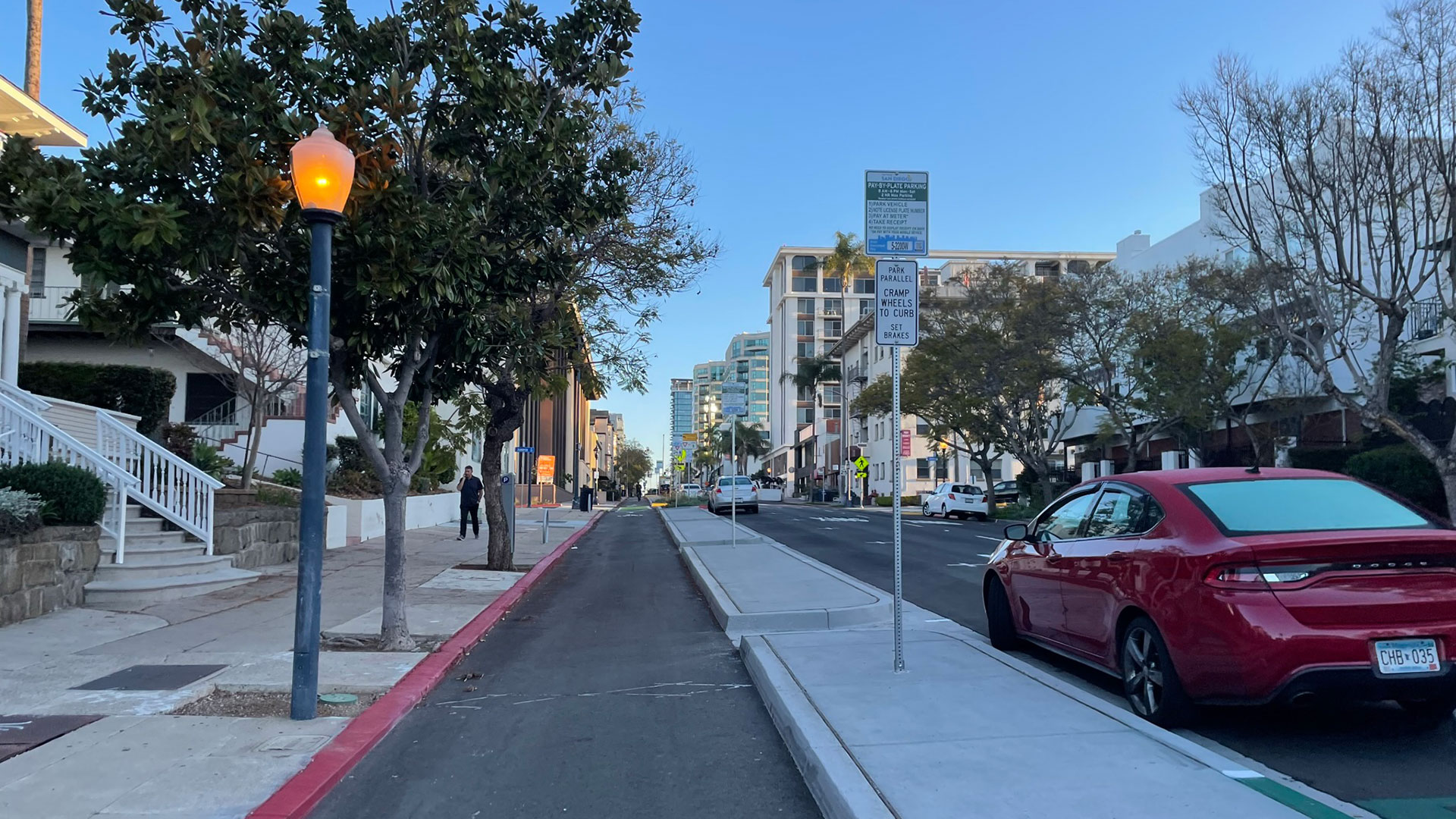 Separated bike lane next to parallel parking spaces.