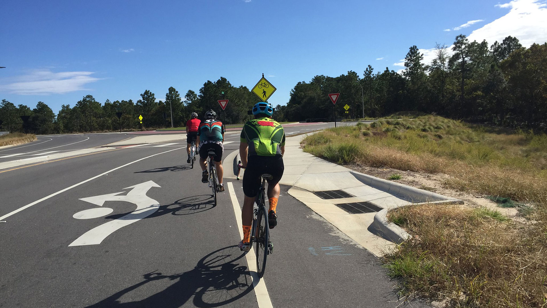 Three bicyclists enter a roundabout