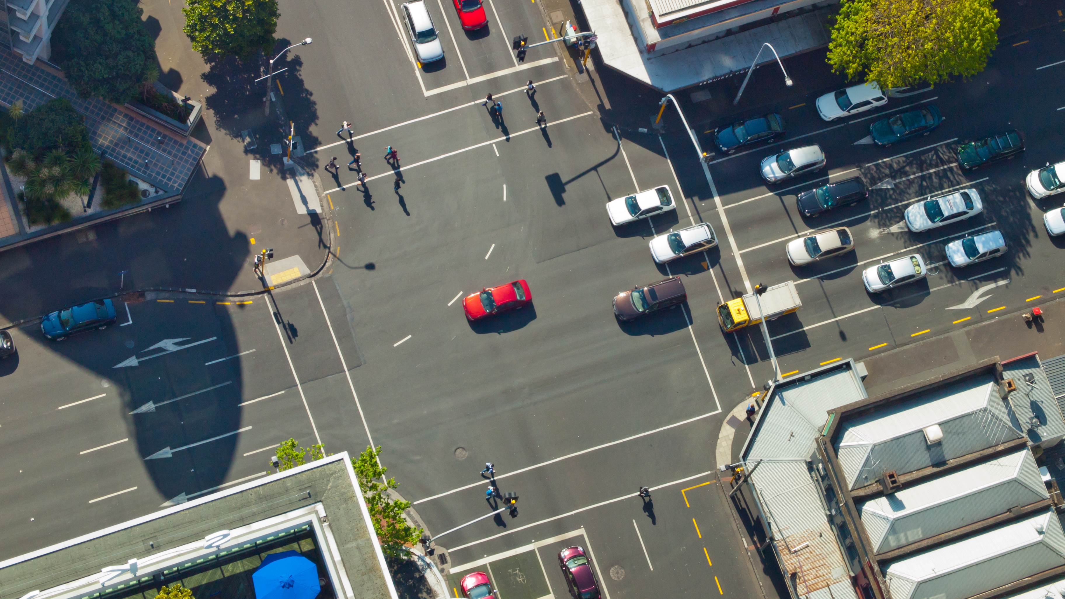 Aerial view of intersection with cars, pedestrians